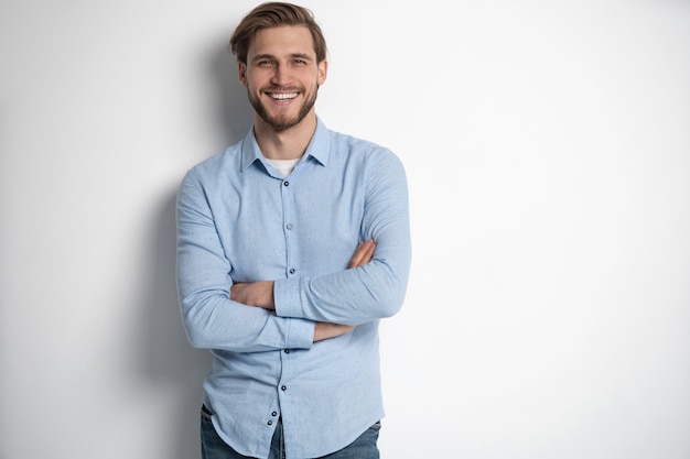 Portrait of a smart young man standing against white background.