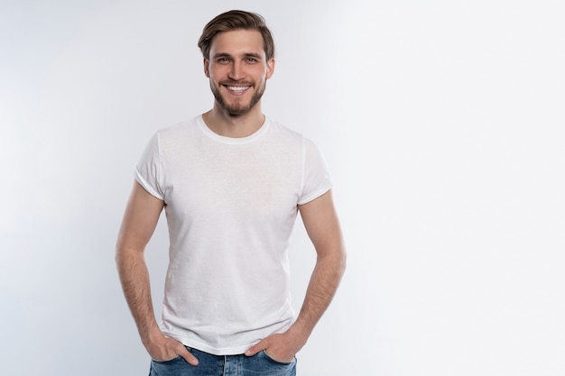 Portrait of a smart young man standing against white background.