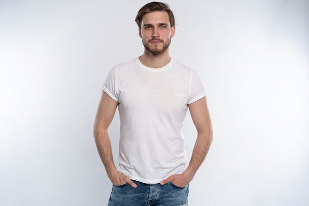 Portrait of a smart young man standing against white background.