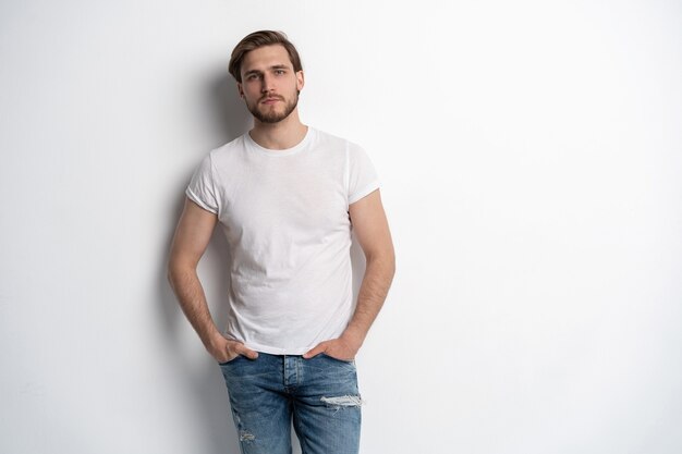 Portrait of a smart young man standing against white background.