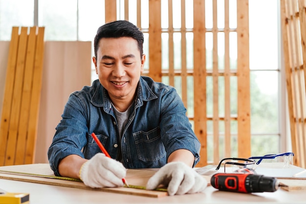 Portrait of smile Asian male father sitting and working on the table with the instrument of measure