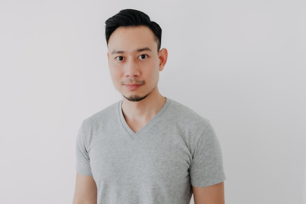 Portrait of smile man wear grey tshirt isolated on white wall