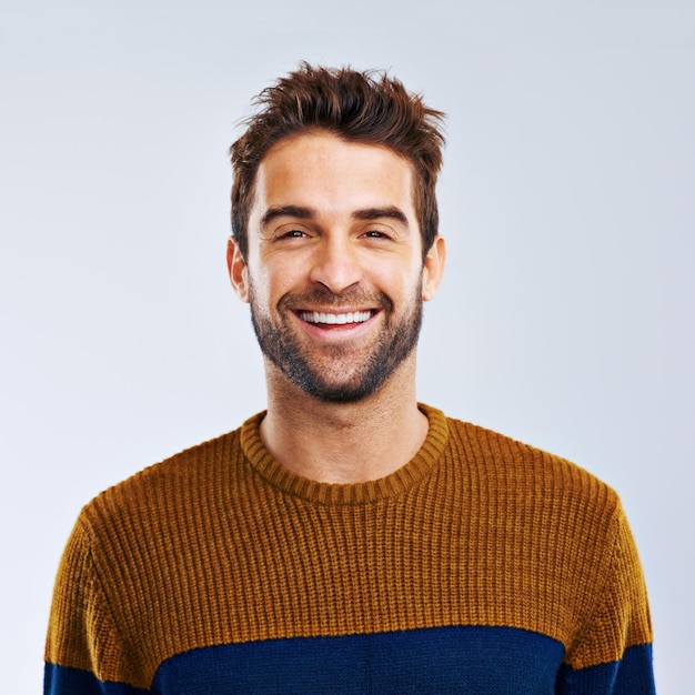 Photo portrait smile and man with positive confidence and carefree against a grey studio background face male person and human with a cheerful attitude freedom and model with joy canada and relax