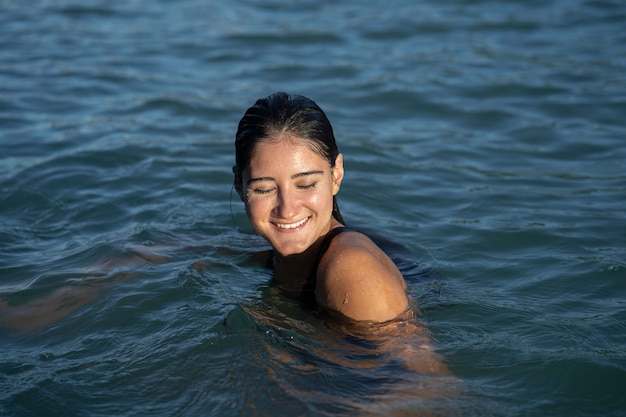 수영을 즐기는 웃는 젊은 여자의 초상화
