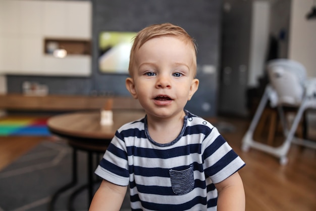 Portrait of smiling adorable little boy with blond hair and blue eyes.