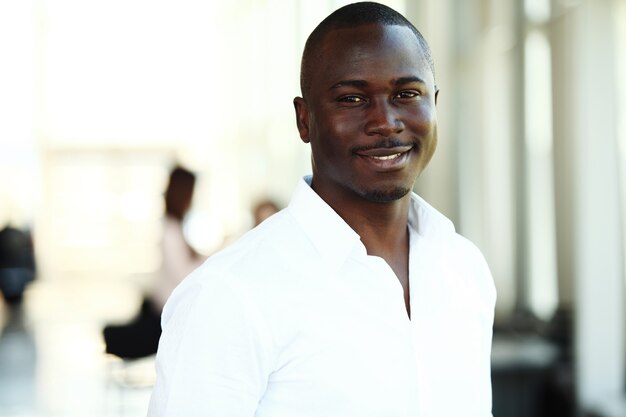 Portrait of smiling African American business man with executives working in background