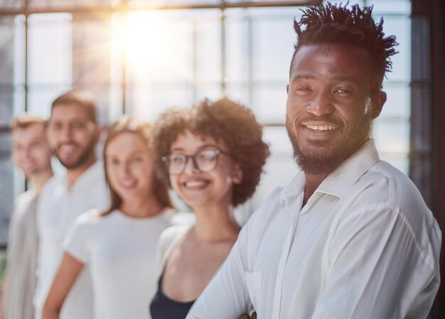 Photo portrait of smiling african american business man with executives working in background