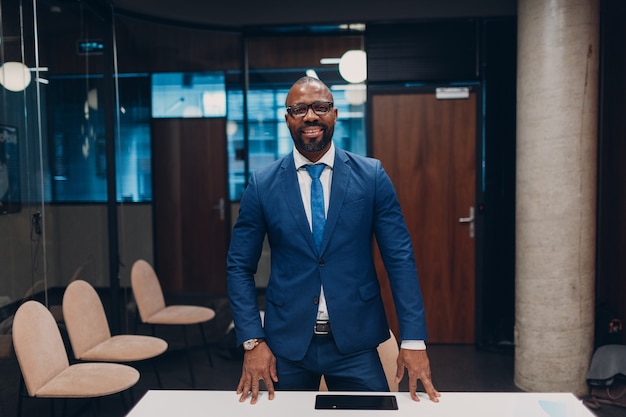 Portrait smiling african american businessman in blue suit in office