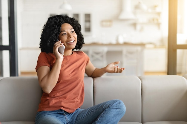 Portrait of smiling african american woman talking on cellphone at home