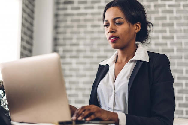 Portrait of smiling African American woman using laptop