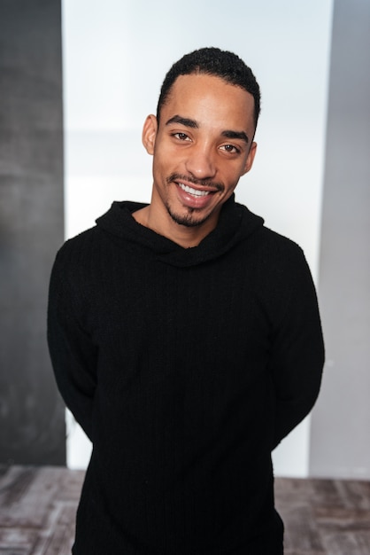 Portrait of smiling african american young man in black hoodie