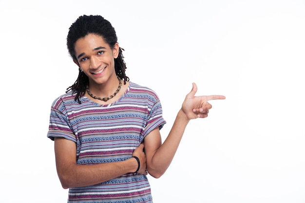 Portrait of a smiling afro american man pointing finger away isolated on a white wall