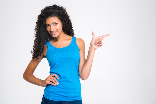 Ritratto di una donna afroamericana sorridente che punta il dito lontano isolato