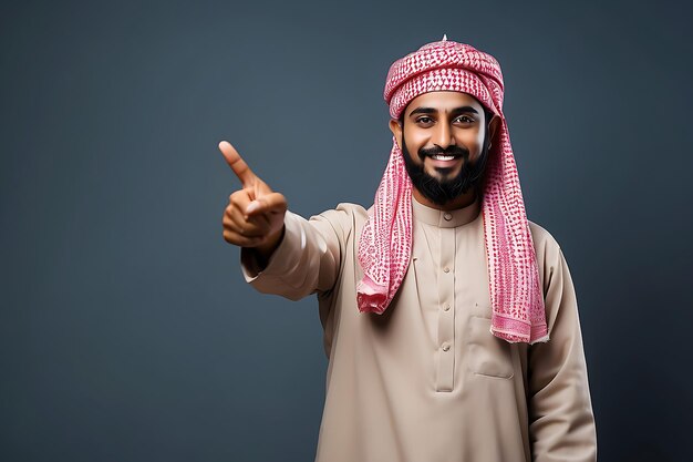 Photo portrait of a smiling arabian man showing thumbs up over grey background