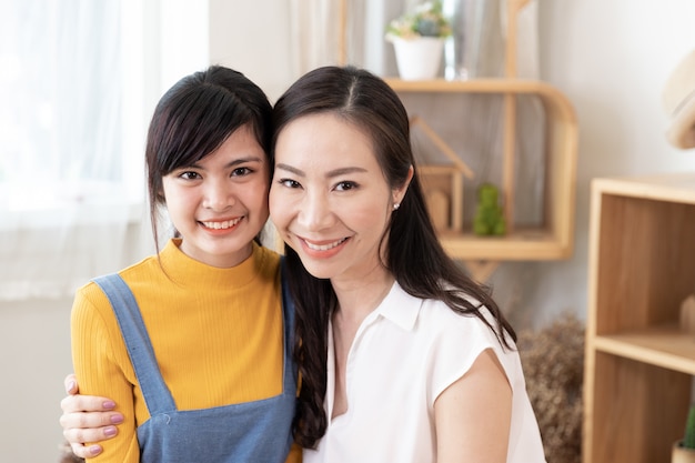 Photo portrait of smiling asian family mom and teenage daughter