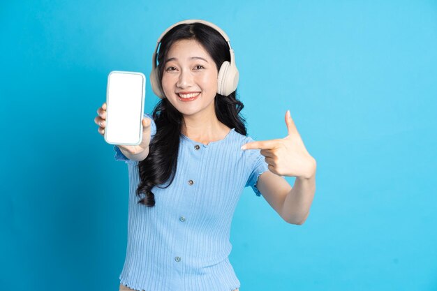 Portrait of smiling asian woman posing on blue background