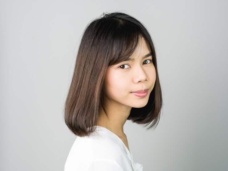 Photo 笑顔のアジアの若い女性の肖像画は、中括弧に入れ