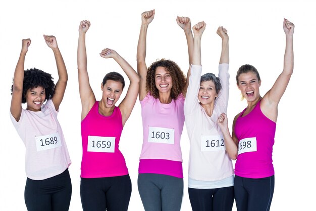 Portrait of smiling athletes with arms raised 