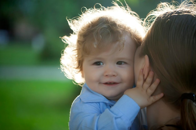 Photo portrait of a smiling baby boy hugging mom