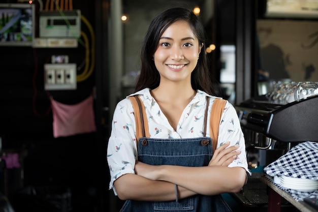 portrait of smiling barista standing at cafe