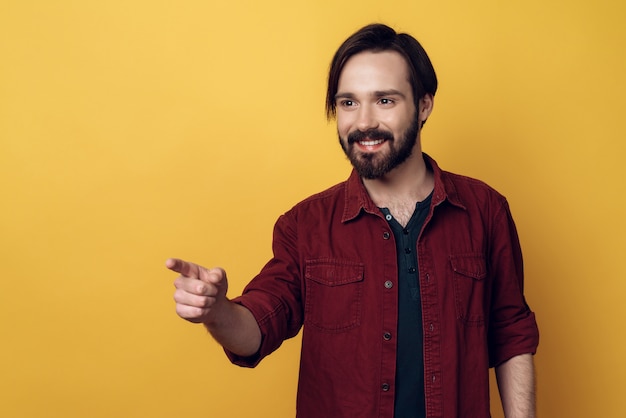 Portrait of smiling bearded man points with finger