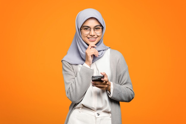 Portrait of smiling beautiful asian woman while holding smartphone