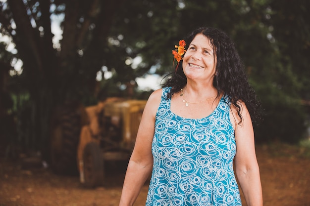 Portrait of smiling beautiful woman in nature with flower on her hair