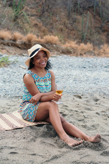 Портрет улыбающейся красивой женщины с белым вином на пляже