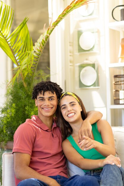 Photo portrait of smiling biracial young boyfriend with girlfriend relaxing on sofa in living room. copy space, unaltered, couple, love, togetherness, lifestyle and home concept.