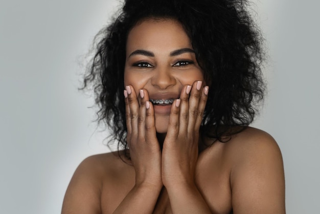 Photo portrait of smiling black woman with dental braces on her teeth