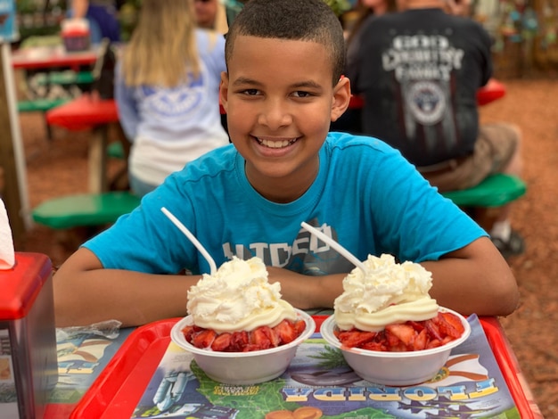 Photo portrait of smiling boy having dessert at restaurant