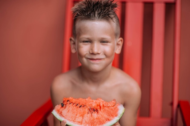 Portrait of smiling boy holding strawberry