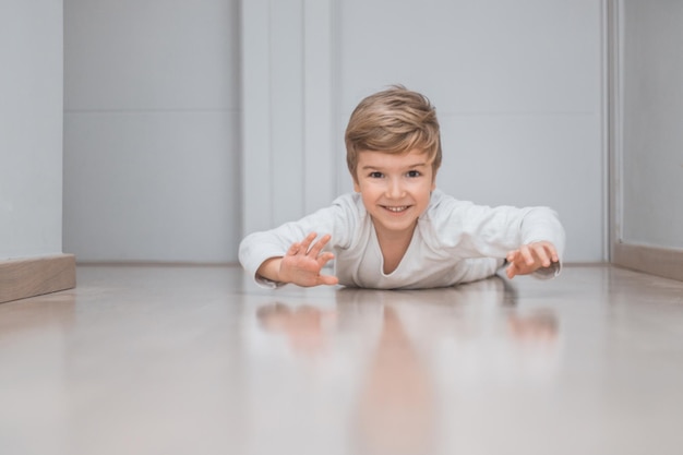 portrait of smiling boy lying on floor at home