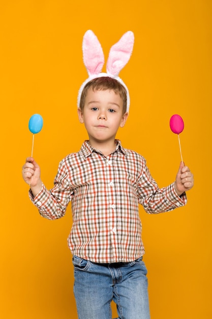 Portrait of smiling boy playing with toys against yellow background