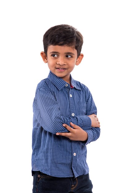 Portrait of a smiling boy posing on a white wall.