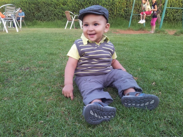 Photo portrait of smiling boy sitting on grass