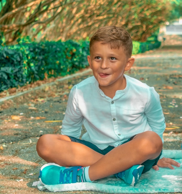 Photo portrait of smiling boy sitting outdoors