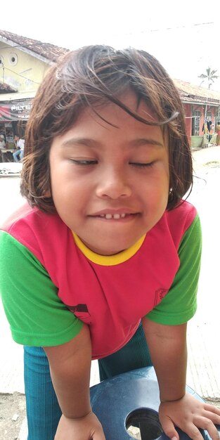 Portrait of smiling boy sitting outdoors