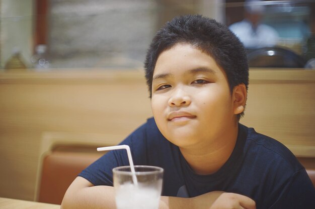 Photo portrait of smiling boy sitting in restaurant