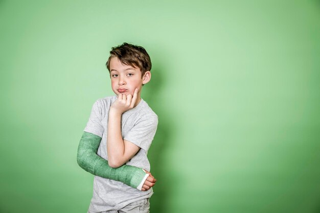 Portrait of smiling boy standing against gray background