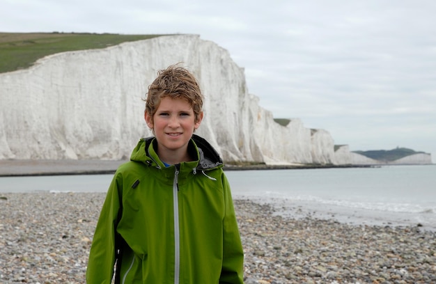 Foto ritratto di un ragazzo sorridente in piedi sulla spiaggia