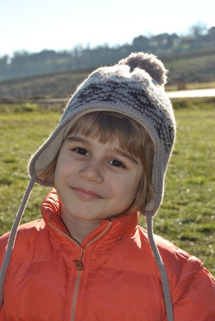 Portrait of smiling boy standing on field during winter