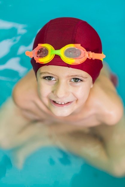 Foto ritratto di un ragazzo sorridente che nuota in piscina