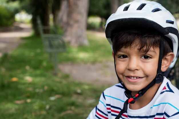 Portrait of smiling boy wearing bicycle helmet in park