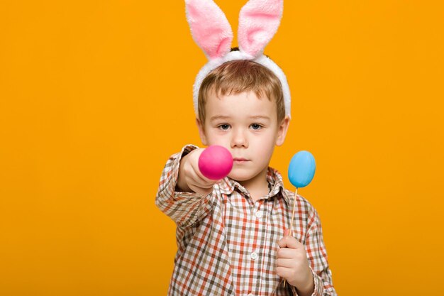 Portrait of smiling boy with balloons against yellow background