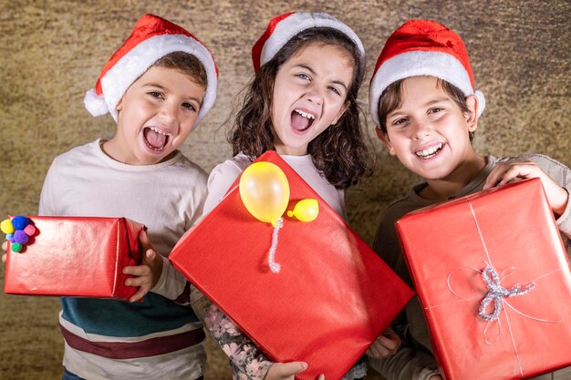 Photo portrait of smiling boys and girl holding gift boxes