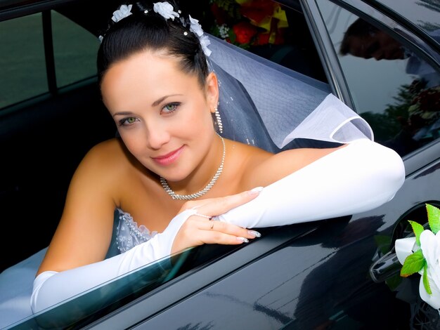 Portrait of the smiling bride in the car