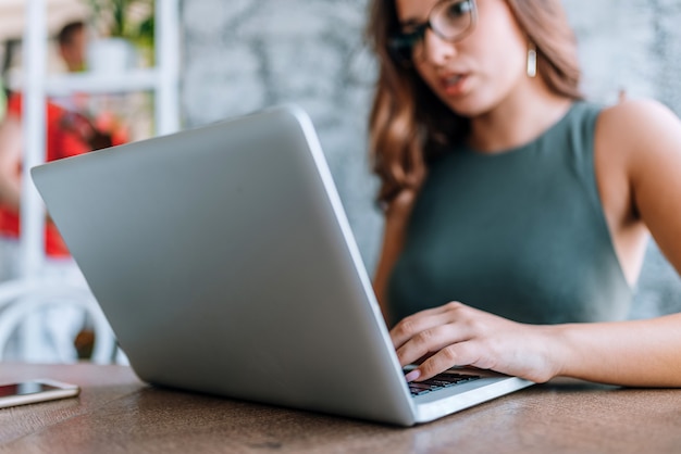 Portrait of a smiling brown haired woman using laptop.