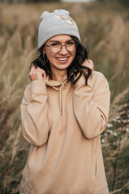 portrait of smiling brunette girl in glasses in the field