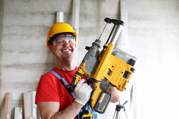 Portrait of smiling builder in boilersuit, protective glasses and helmet.